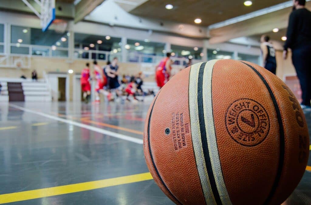 Basketball sitting on a court inside a gymnasium.