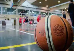 Basketball sitting on a court inside a gymnasium.