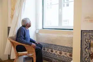 Man sitting in chair looking out the window