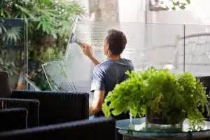 Man cleaning windows: is window cleaning usually included with commercial cleaning?