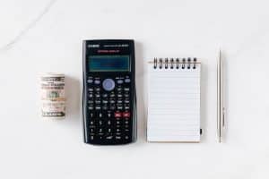 Note pad with calculator and money rolled up: how a commercial cleaning company can save you money