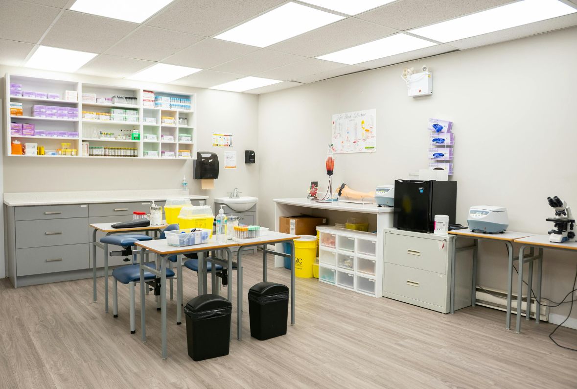 Sterile medical laboratory with stocked shelves, gray cabinets, and equipment on white counters.